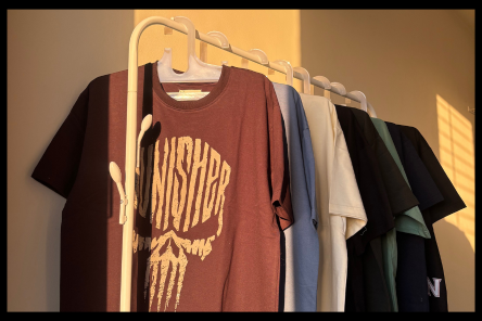 T-shirt manufacturing sample collection displayed on a stand